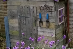 A rustic shed made completely from reclaimed pallet wood