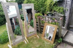 a pair of stund up mirrors plus a large wall mirror all framed in pallet wood